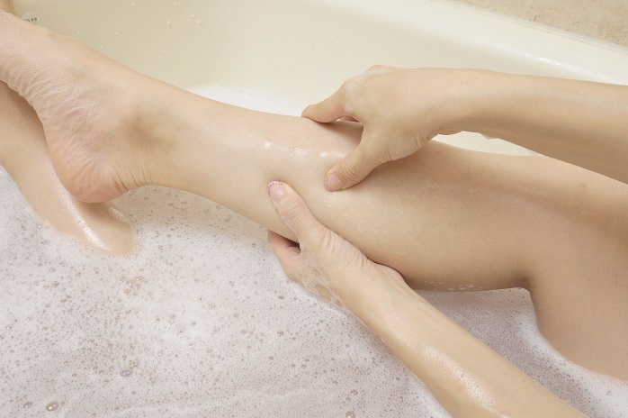 お風呂で足をマッサージする手