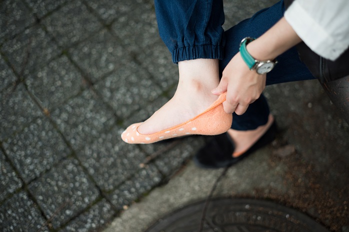 靴擦れ対策として靴下をはいている女性の足